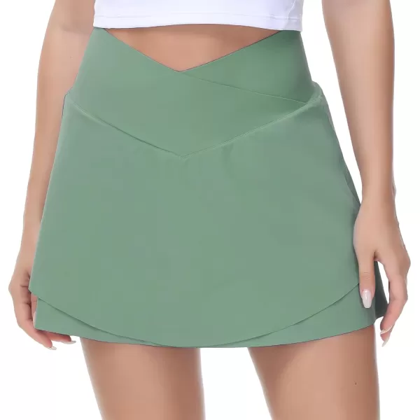 imageTHE GYM PEOPLE Womens Cross Waist Tennis Skirts with Cutting Hem Golf Skorts with Inner Mesh Pockets ShortsJasmine Green